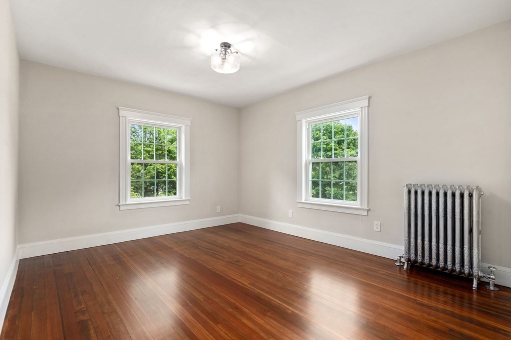 95 Russett Road Boston, MA 02132 - Photo 27 of 42 a view of an empty room with wooden floor and a window