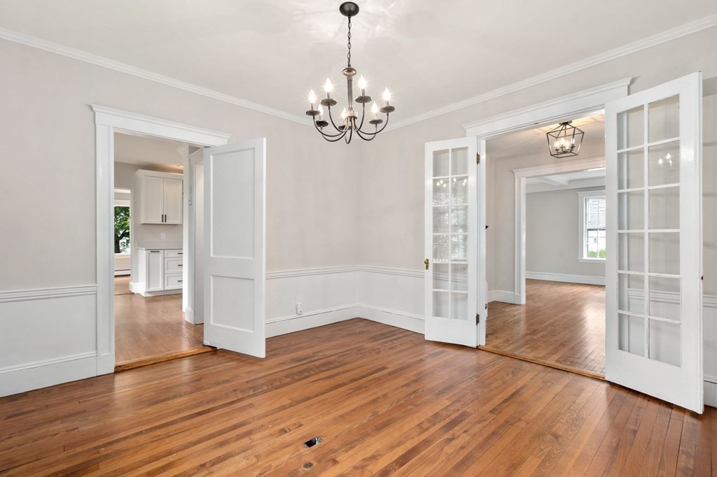 95 Russett Road Boston, MA 02132 - Photo 33 of 42 a view of an empty room with wooden floor and a chandelier