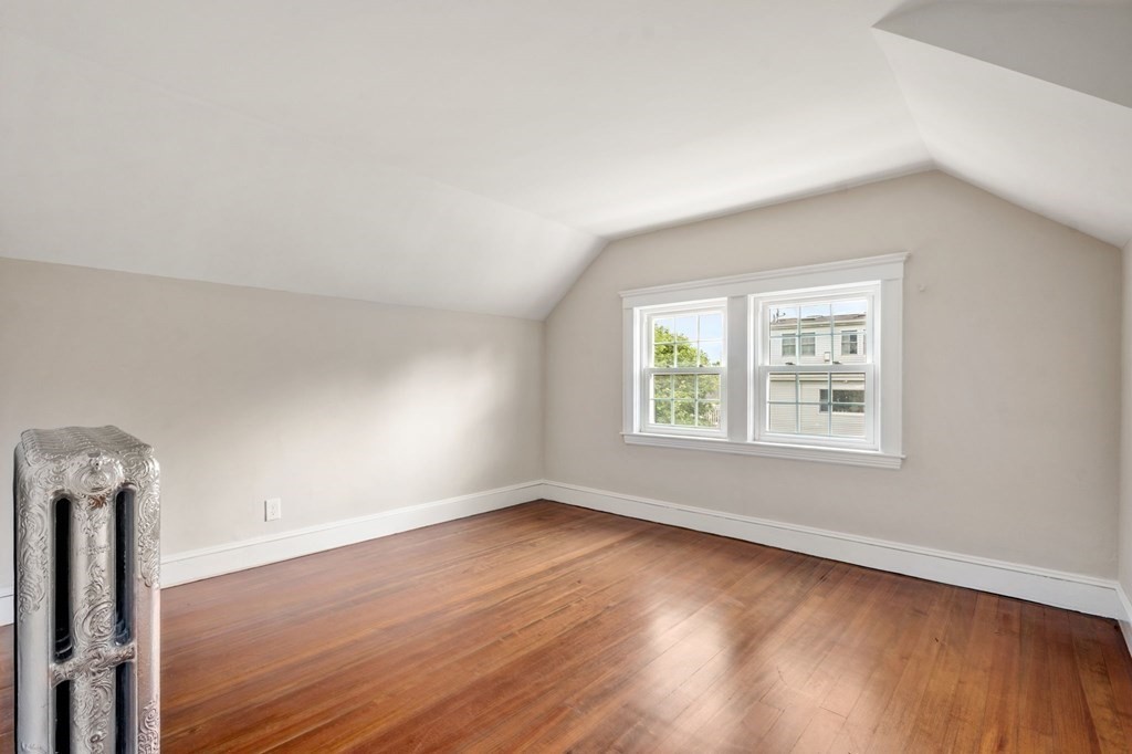 95 Russett Road Boston, MA 02132 - Photo 34 of 42 an empty room with wooden floor and windows