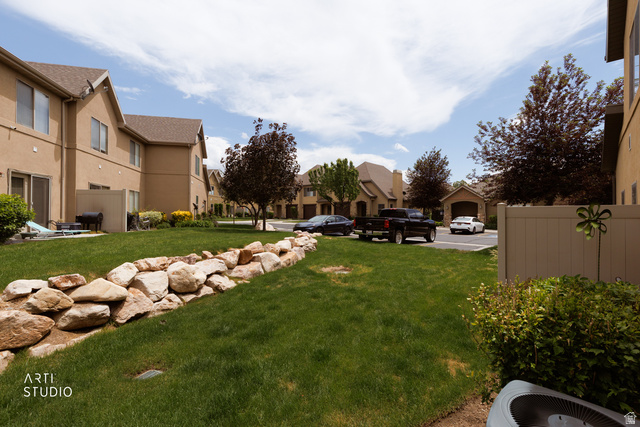 6761 950 East Midvale, UT 84047 - Photo 27 of 44 Expansive green space featuring a decorative rock border and manicured lawn