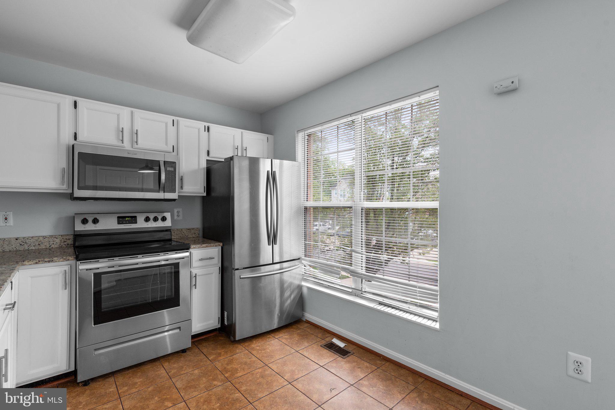 2204 Commissary Circle Odenton, MD 21113 - Photo 14 of 49 a kitchen with white cabinets and stainless steel appliances