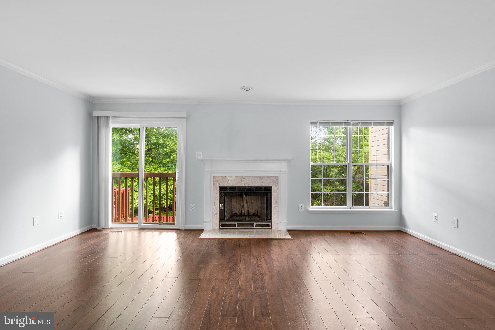 2204 Commissary Circle Odenton, MD 21113 - Photo 7 of 49 an empty room with wooden floor windows and a fireplace