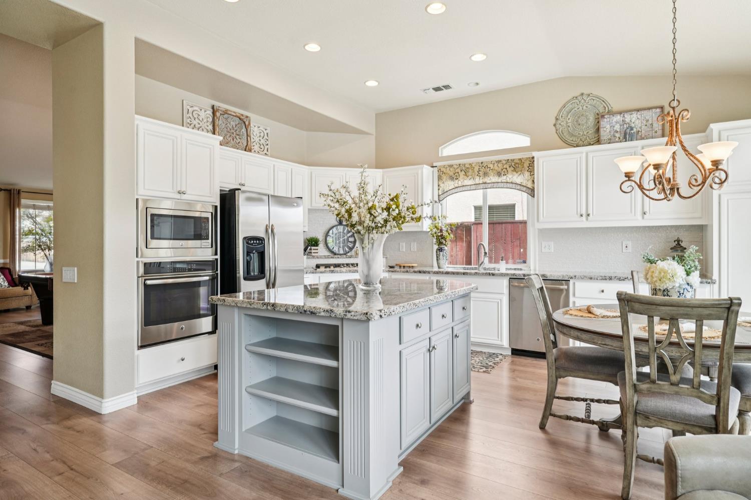 164 Legacy Street Manteca, CA 95337 - Photo 14 of 33 a kitchen with stainless steel appliances granite countertop a kitchen island hardwood floor and a sink