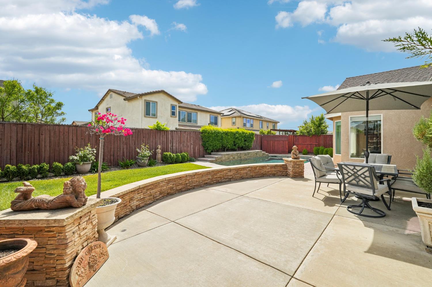 164 Legacy Street Manteca, CA 95337 - Photo 32 of 33 a view of a patio with table and chairs potted plants with wooden fence
