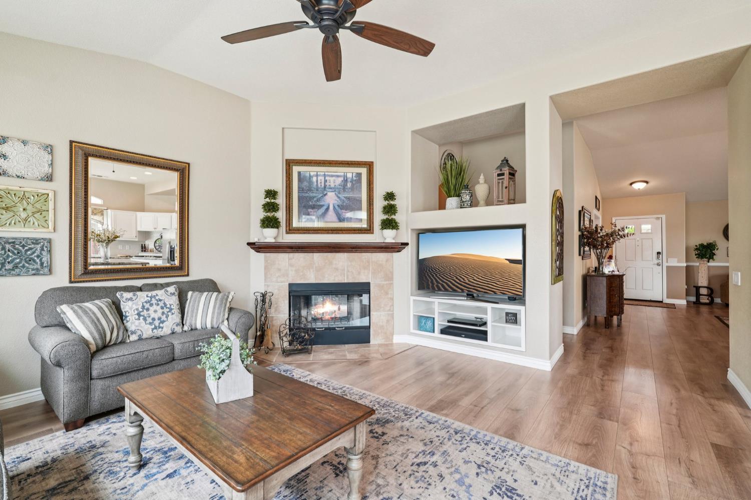 164 Legacy Street Manteca, CA 95337 - Photo 7 of 33 a living room with furniture a fireplace and a flat screen tv