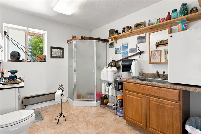 11290 South Southfield Road Mayfield, UT 84643 - Photo 39 of 103 Three-piece bathroom featuring a corner shower, toilet, and vanity with an integrated sink