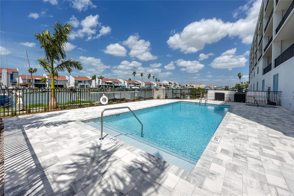 400 150th Avenue, Unit 501 Madeira Beach, FL 33708 - Photo 11 of 76 a view of a swimming pool with a lounge chairs