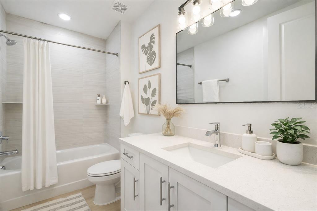 400 150th Avenue, Unit 501 Madeira Beach, FL 33708 - Photo 36 of 76 a bathroom with a sink a toilet and a large mirror