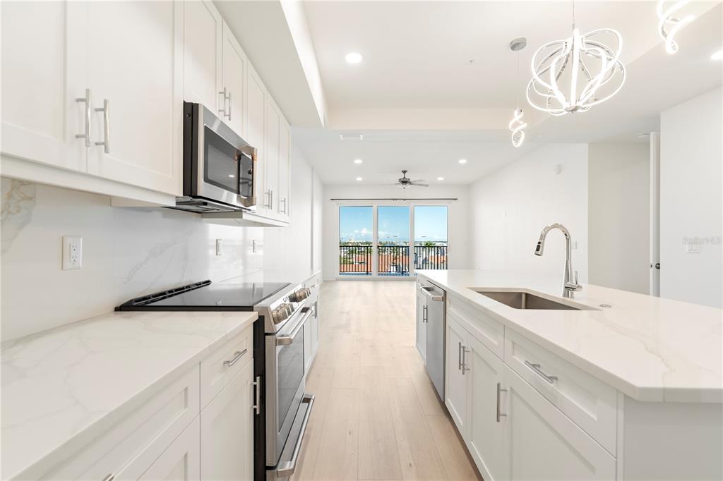 400 150th Avenue, Unit 501 Madeira Beach, FL 33708 - Photo 38 of 76 a kitchen with sink a microwave and cabinets