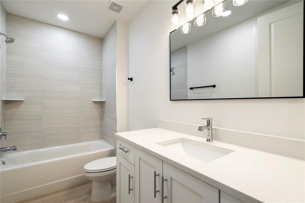 400 150th Avenue, Unit 501 Madeira Beach, FL 33708 - Photo 48 of 76 a bathroom with a sink a toilet a tub a mirror and vanity