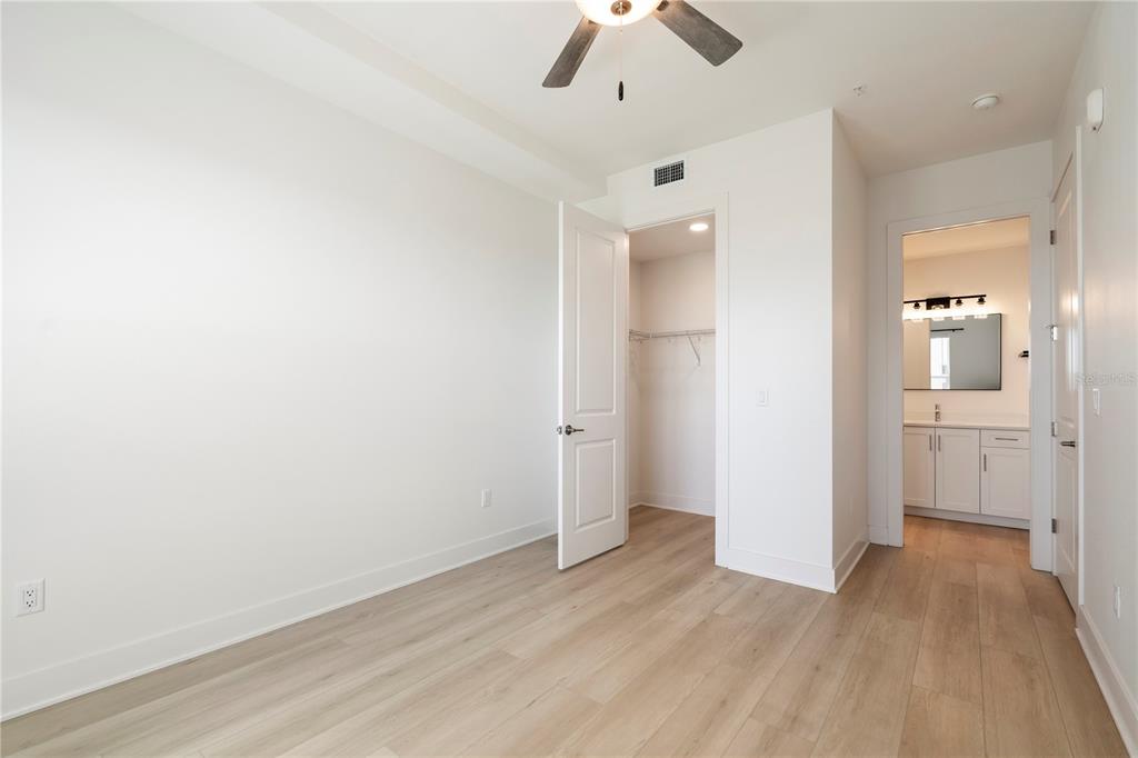 400 150th Avenue, Unit 501 Madeira Beach, FL 33708 - Photo 50 of 76 an empty room with wooden floor and ceiling fan