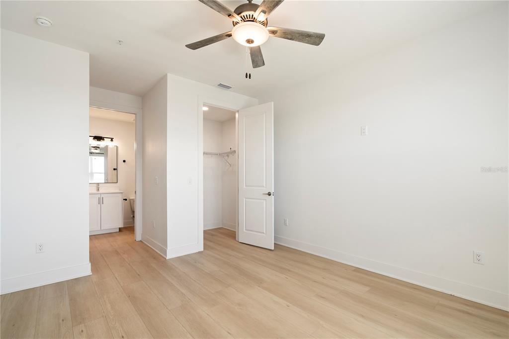 400 150th Avenue, Unit 501 Madeira Beach, FL 33708 - Photo 52 of 76 wooden floor in an empty room with a ceiling fan