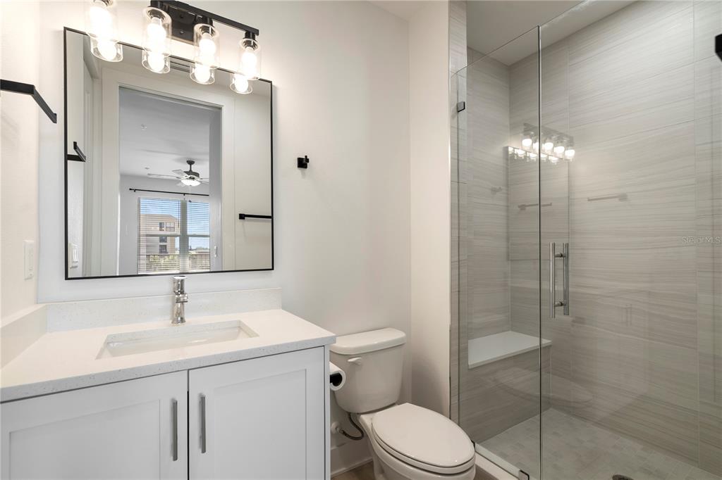 400 150th Avenue, Unit 501 Madeira Beach, FL 33708 - Photo 53 of 76 a bathroom with a sink vanity granite toilet and shower