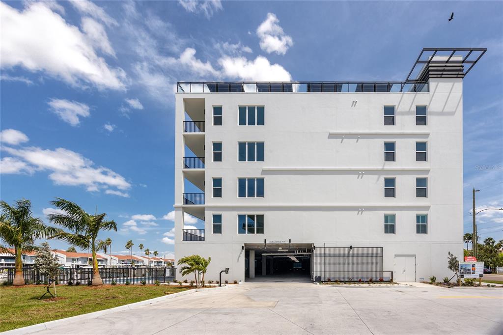 400 150th Avenue, Unit 501 Madeira Beach, FL 33708 - Photo 6 of 76 a front view of a building with lot of cars and trees