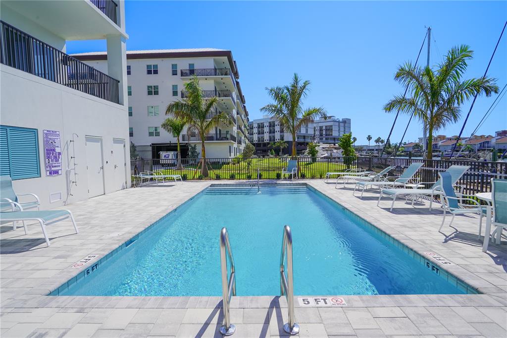 400 150th Avenue, Unit 501 Madeira Beach, FL 33708 - Photo 7 of 76 a view of a swimming pool with a lounge chairs