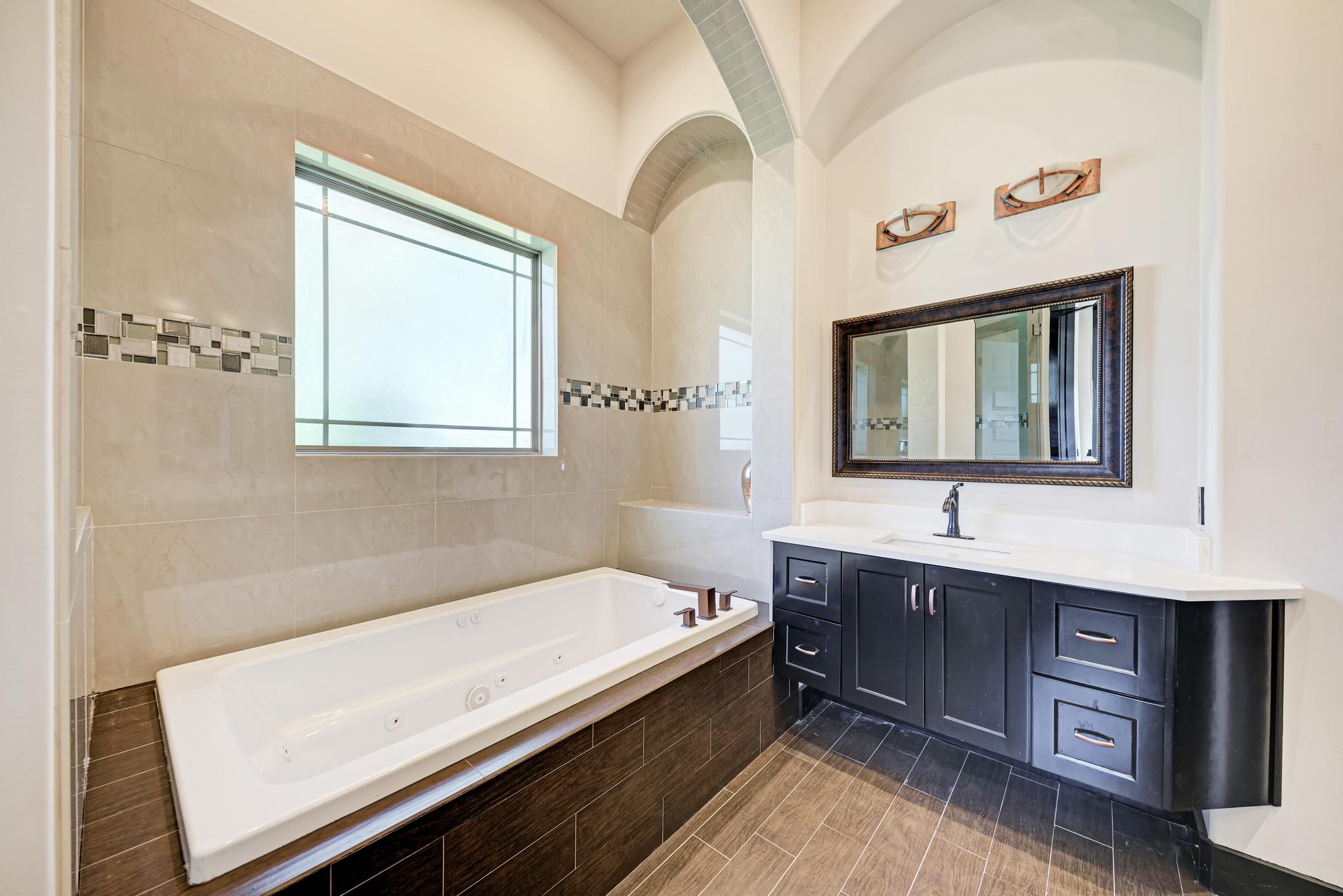 104 Spring Valley Street Hutto, TX 78634 - Photo 17 of 40 Full bathroom with vanity and a tub with jets
