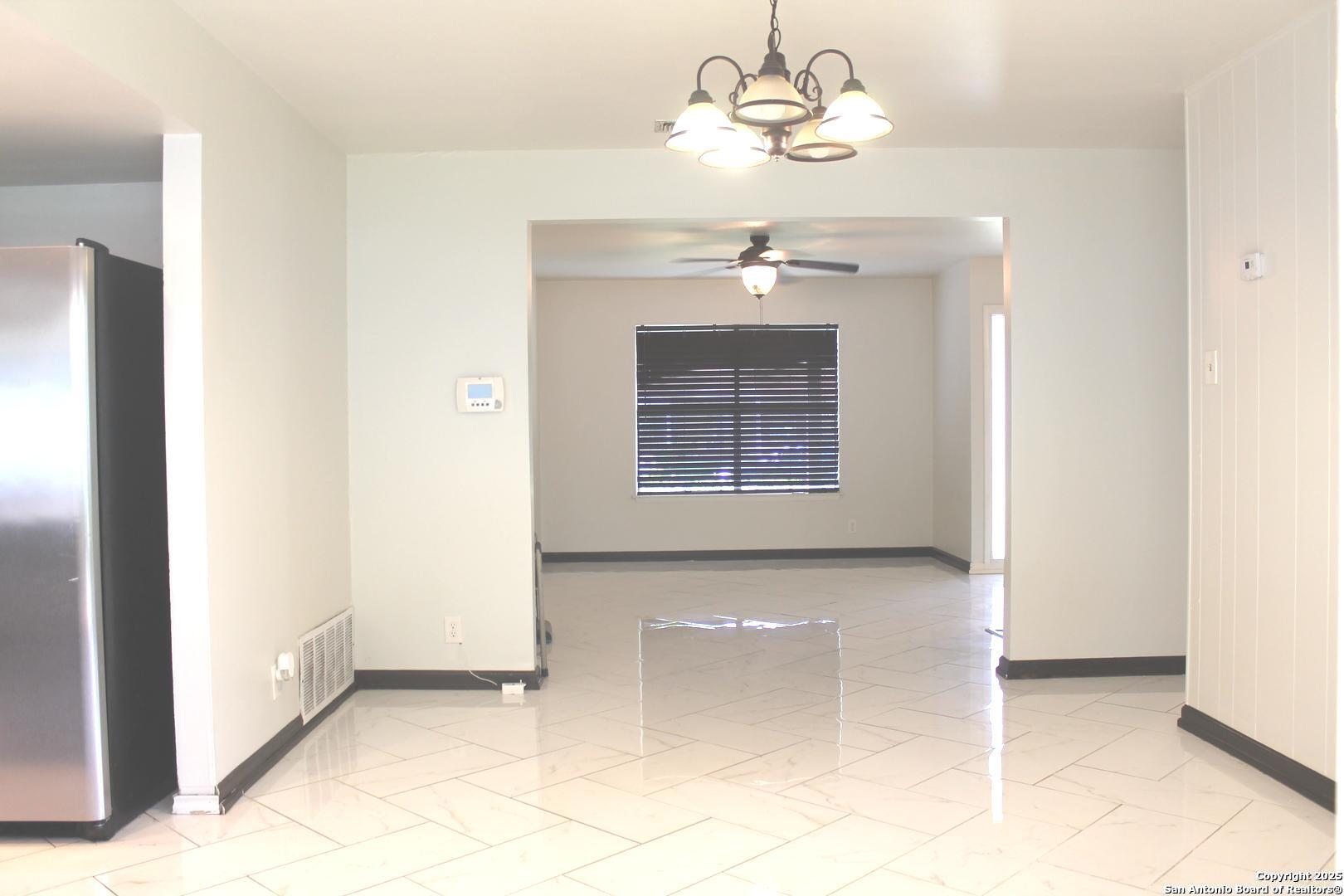 5142 Village Court San Antonio, TX 78218 - Photo 4 of 14 a view of a room with a chandelier fan and a bathroom