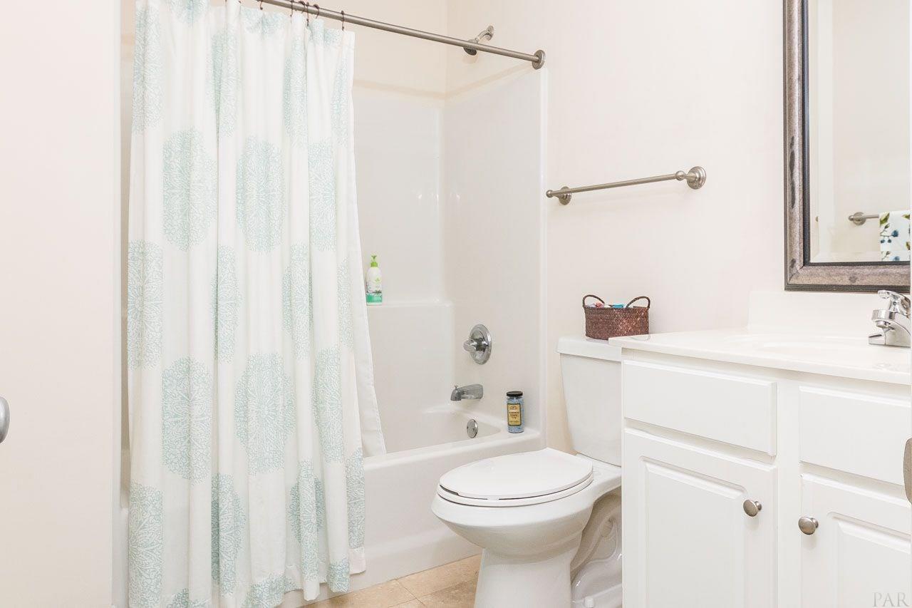 13928 River Road, Unit 504 Perdido Key, FL 32507 - Photo 28 of 40 a bathroom with a sink a toilet and shower curtain