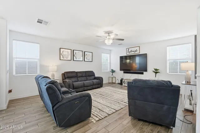 a view of an empty room with a chandelier fan