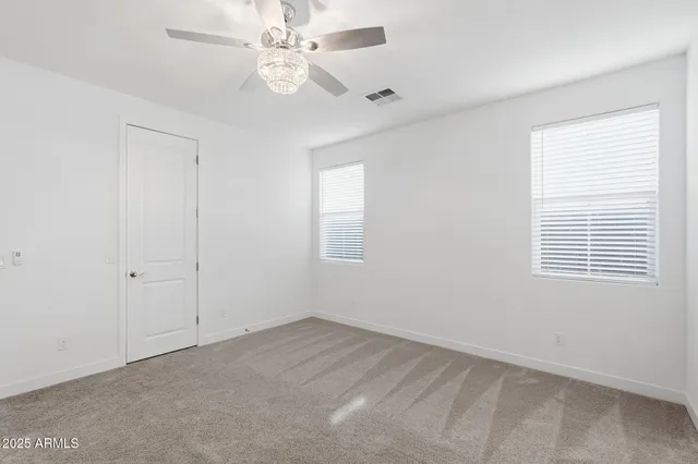 a spacious bedroom with a bed and a chandelier