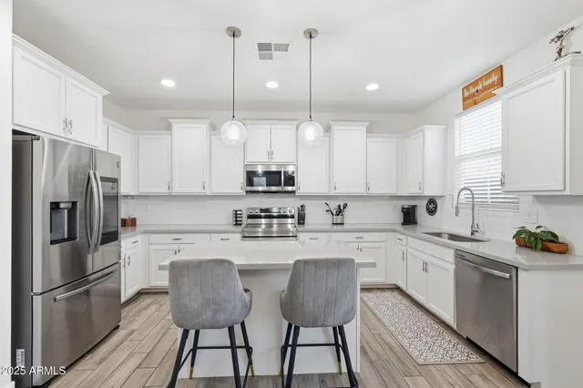 a kitchen with stainless steel appliances a sink a stove and cabinets