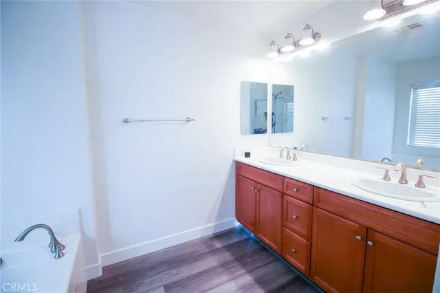 a spacious bathroom with a double vanity sink and mirror