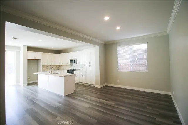 a kitchen with a sink wooden floor and white cabinets