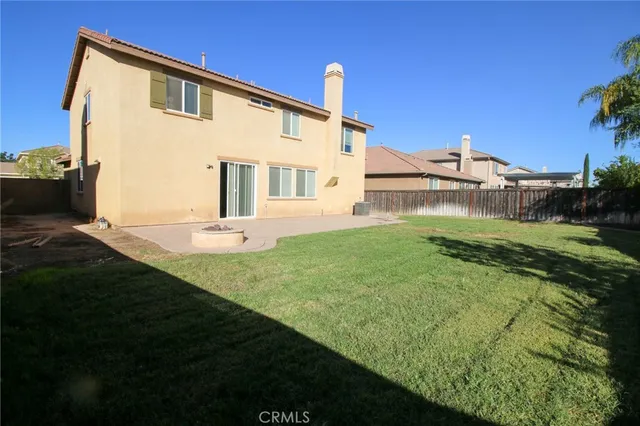 a backyard of a house with table and chairs