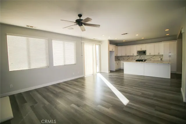 a view of a kitchen with a sink and dishwasher a refrigerator with wooden floor