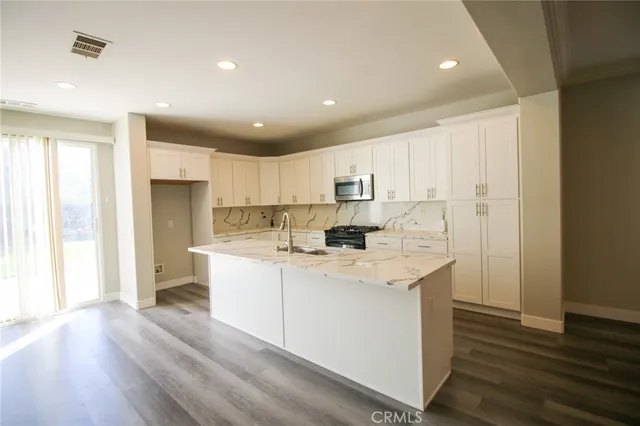 a kitchen with a sink a refrigerator and wooden floor