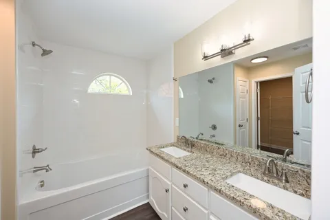 a bathroom with a granite countertop sink a large mirror and shower