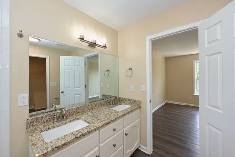 a bathroom with a granite countertop sink and a mirror
