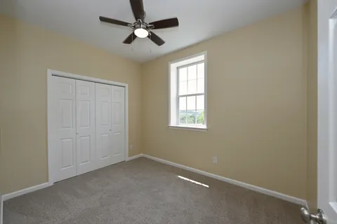 an empty room with a window and a fan