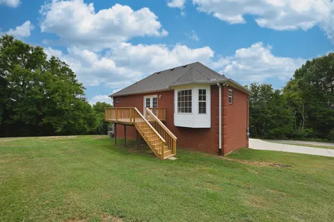 a view of a house with a yard and sitting area