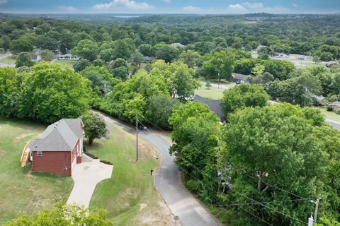 an aerial view of a house with a yard and lake view
