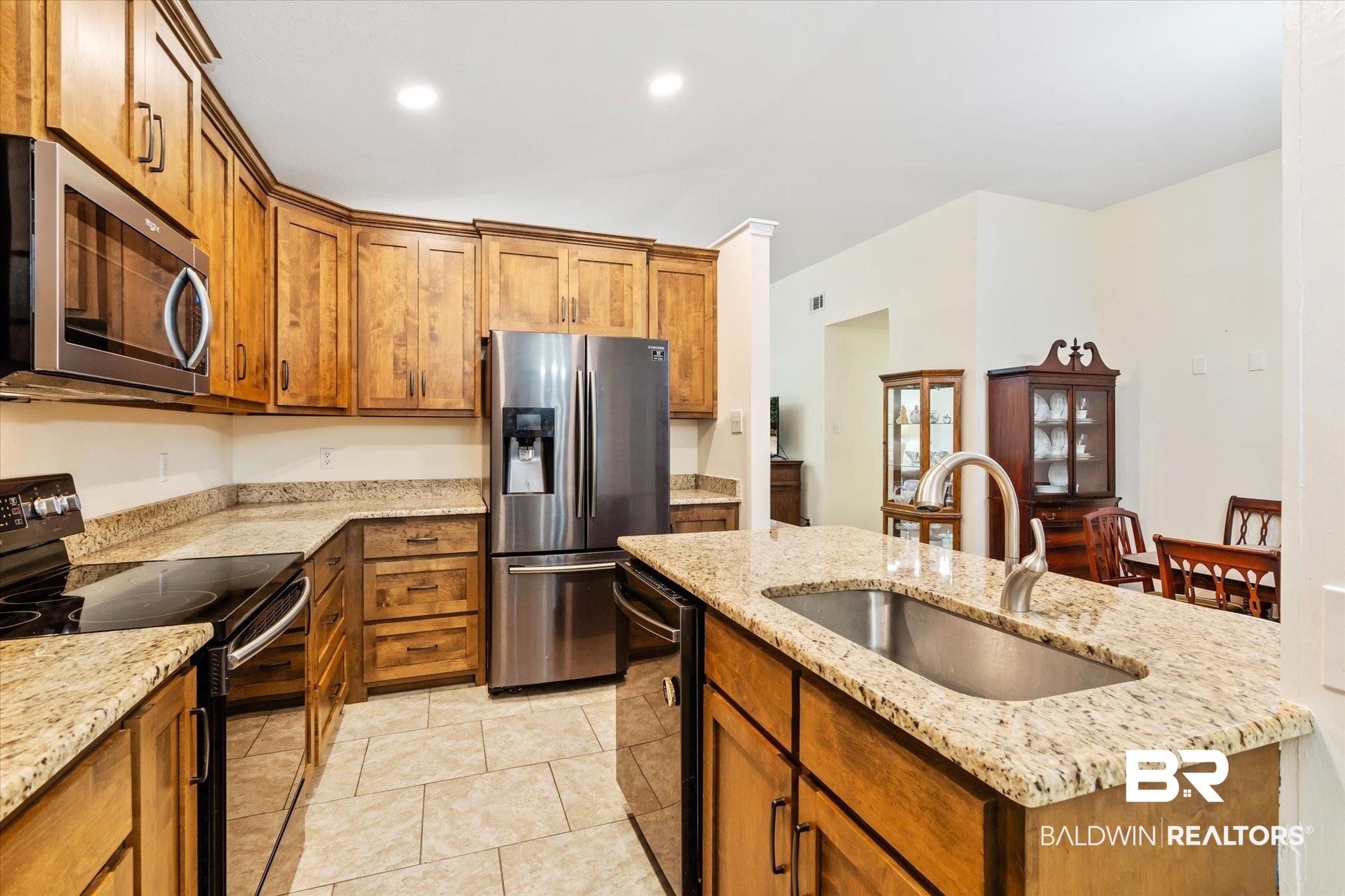 7236 Highpointe Place East Daphne, AL 36527 - Photo 10 of 32 Kitchen with a kitchen island with sink, light tile patterned floors, stainless steel appliances, sink, and light stone countertops