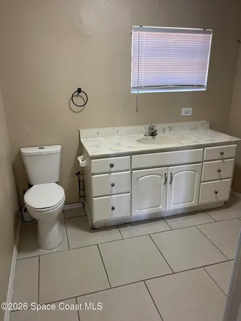 a bathroom with a granite countertop toilet sink and mirror