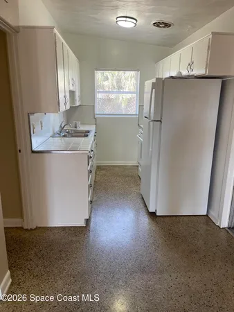 a view of a refrigerator in kitchen and wooden floor
