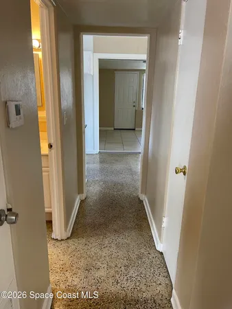 view of a hallway with wooden floor and a bathroom