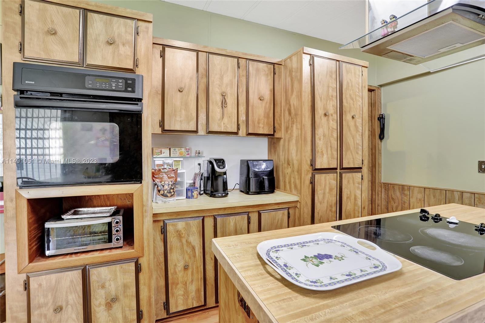1640 Southwest 66th Avenue Boca Raton, FL 33428 - Photo 18 of 36 a kitchen with stainless steel appliances granite countertop a refrigerator a stove a sink dishwasher and cabinets with wooden floor
