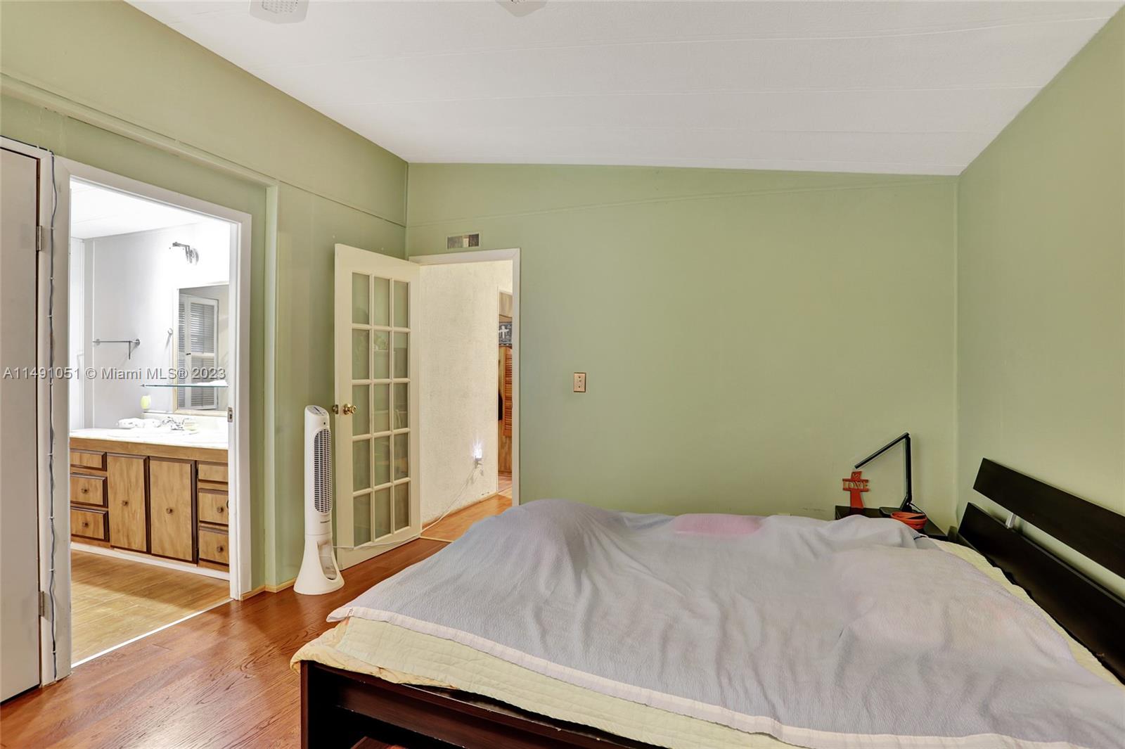 1640 Southwest 66th Avenue Boca Raton, FL 33428 - Photo 24 of 36 a bedroom with a bed and wooden floor