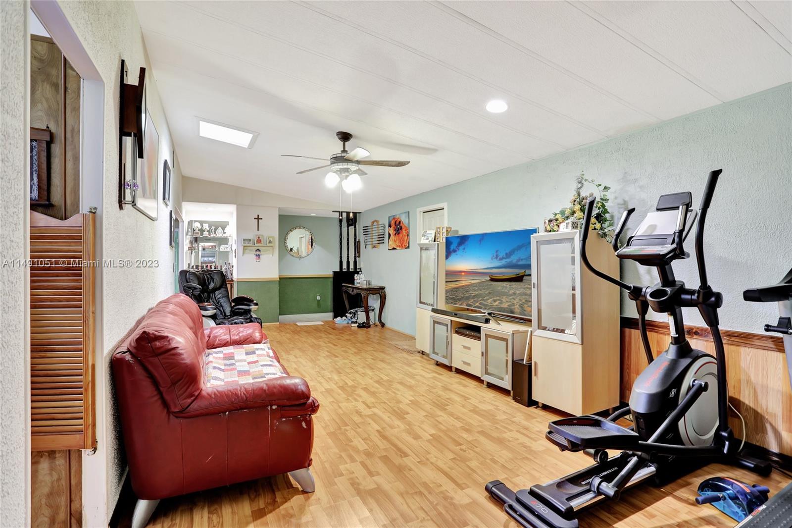 1640 Southwest 66th Avenue Boca Raton, FL 33428 - Photo 10 of 36 a living room with furniture gym equipment and a flat screen tv