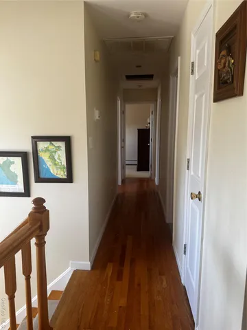 a view of a hallway with wooden floor and stairs