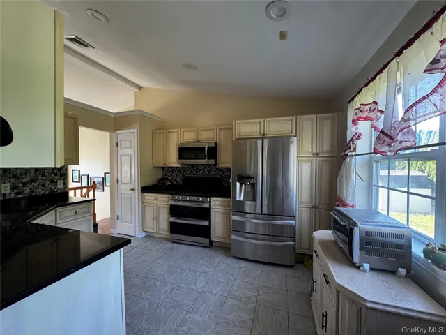 a kitchen with stainless steel appliances and chandelier