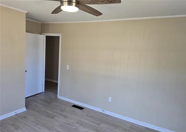 a view of an empty room with wooden floor