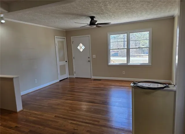 a view of a livingroom with wooden floor and a window