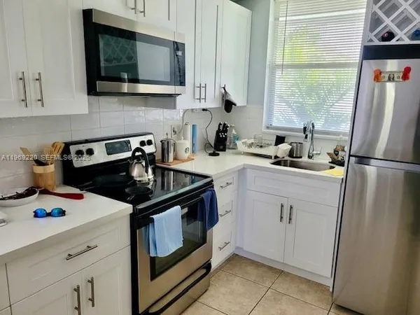a kitchen with a stove a sink and a microwave