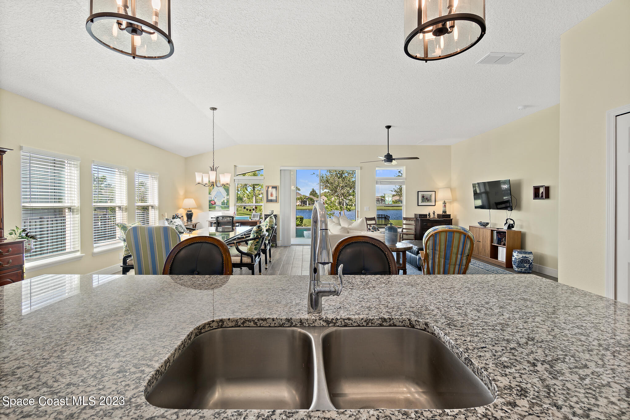 4465 Ruthann Circle Melbourne, FL 32934 - Photo 12 of 42 a kitchen with a faucet a chandelier and living area view