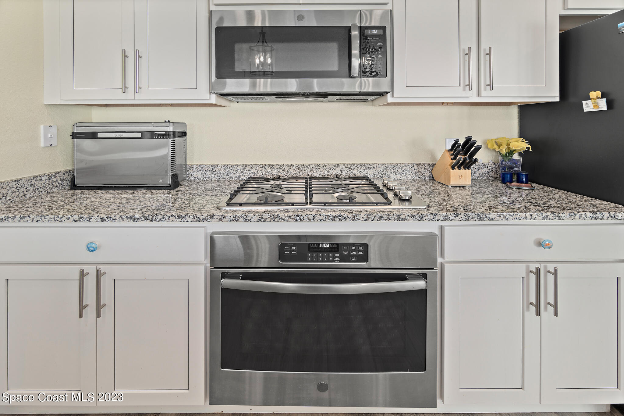 4465 Ruthann Circle Melbourne, FL 32934 - Photo 13 of 42 a kitchen with granite countertop white cabinets and stainless steel appliances