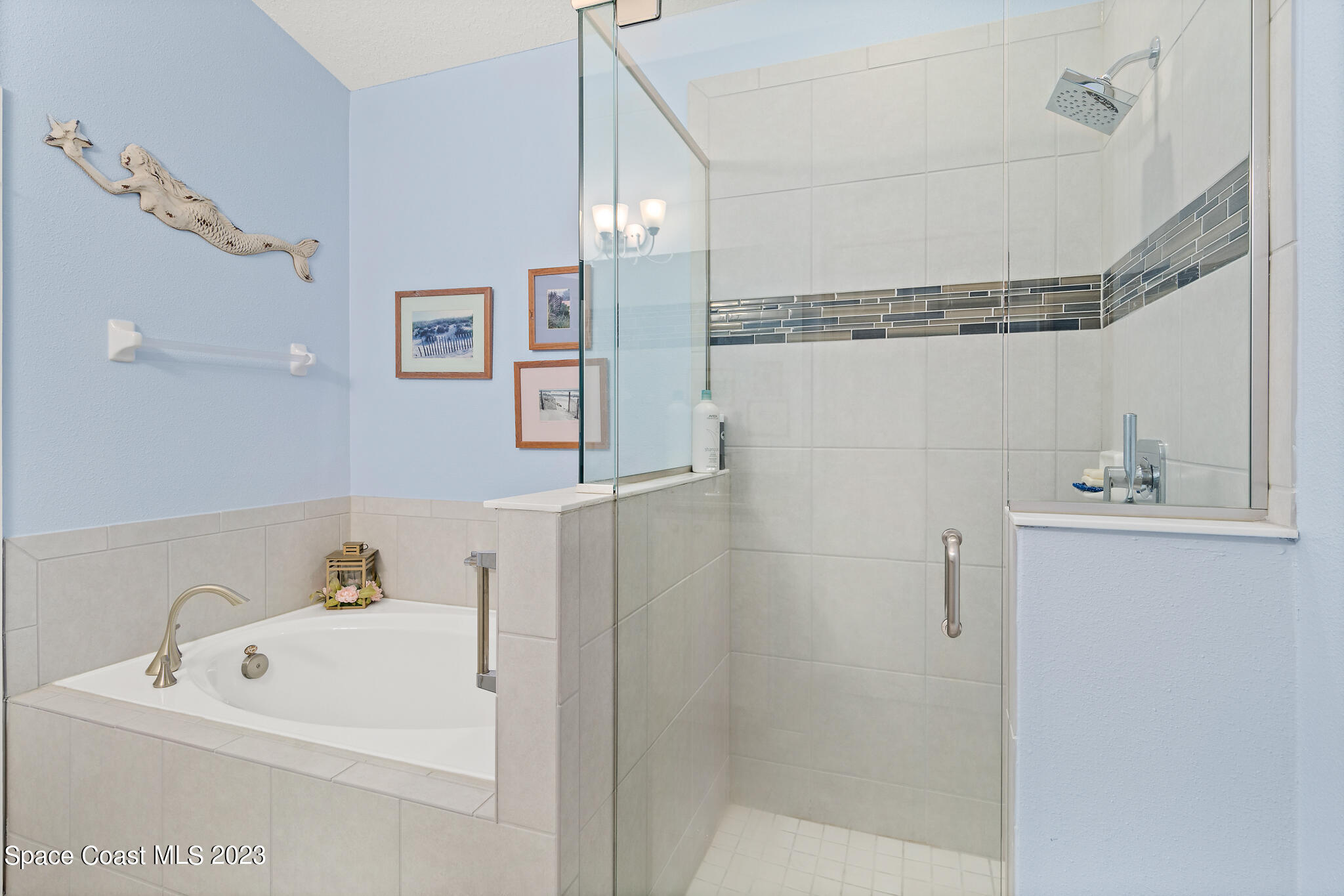 4465 Ruthann Circle Melbourne, FL 32934 - Photo 24 of 42 a bathroom with a white bath tub a sink and glass door